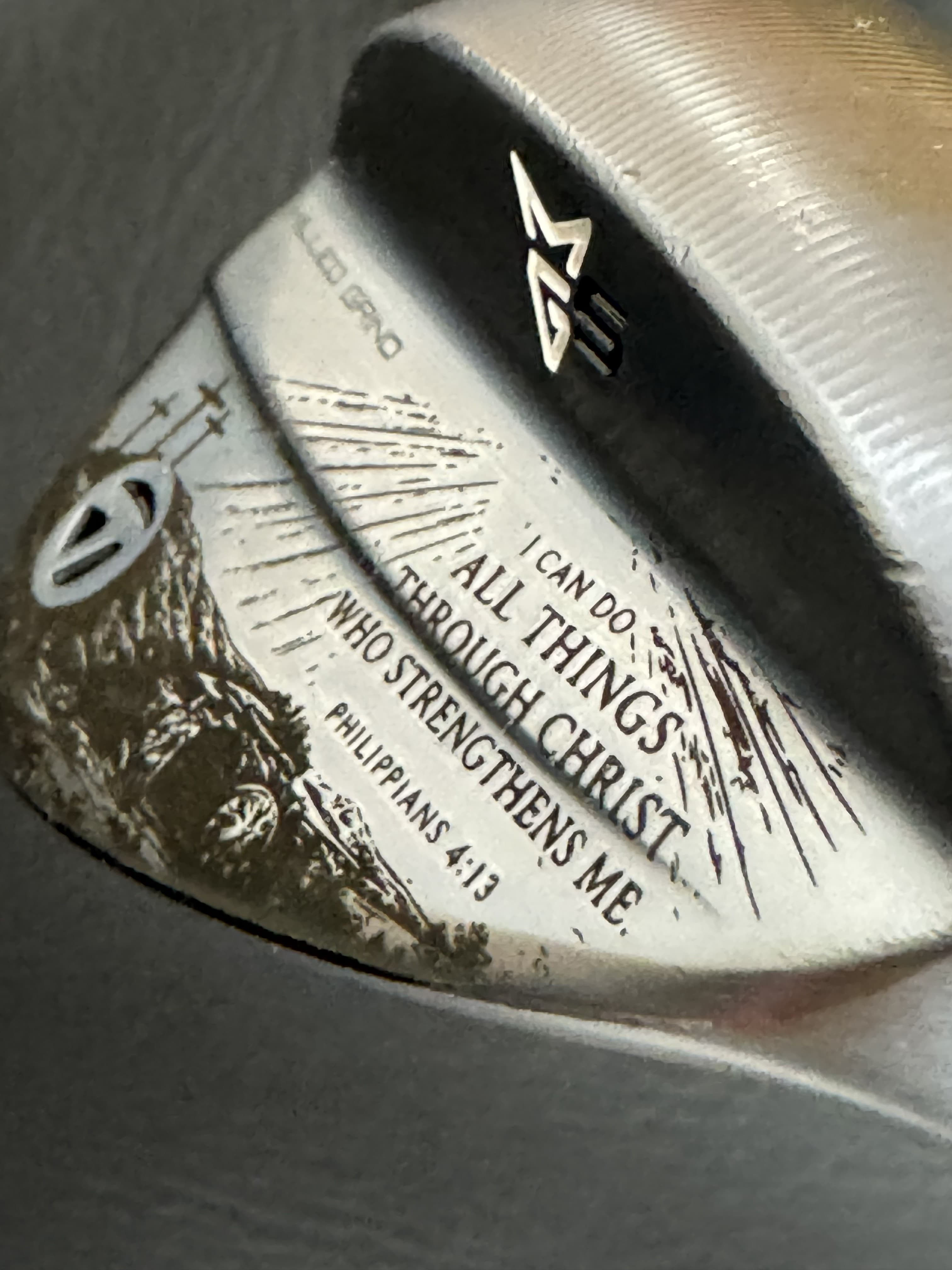 Close-up of Philippians 4:13 engraved on a TaylorMade wedge