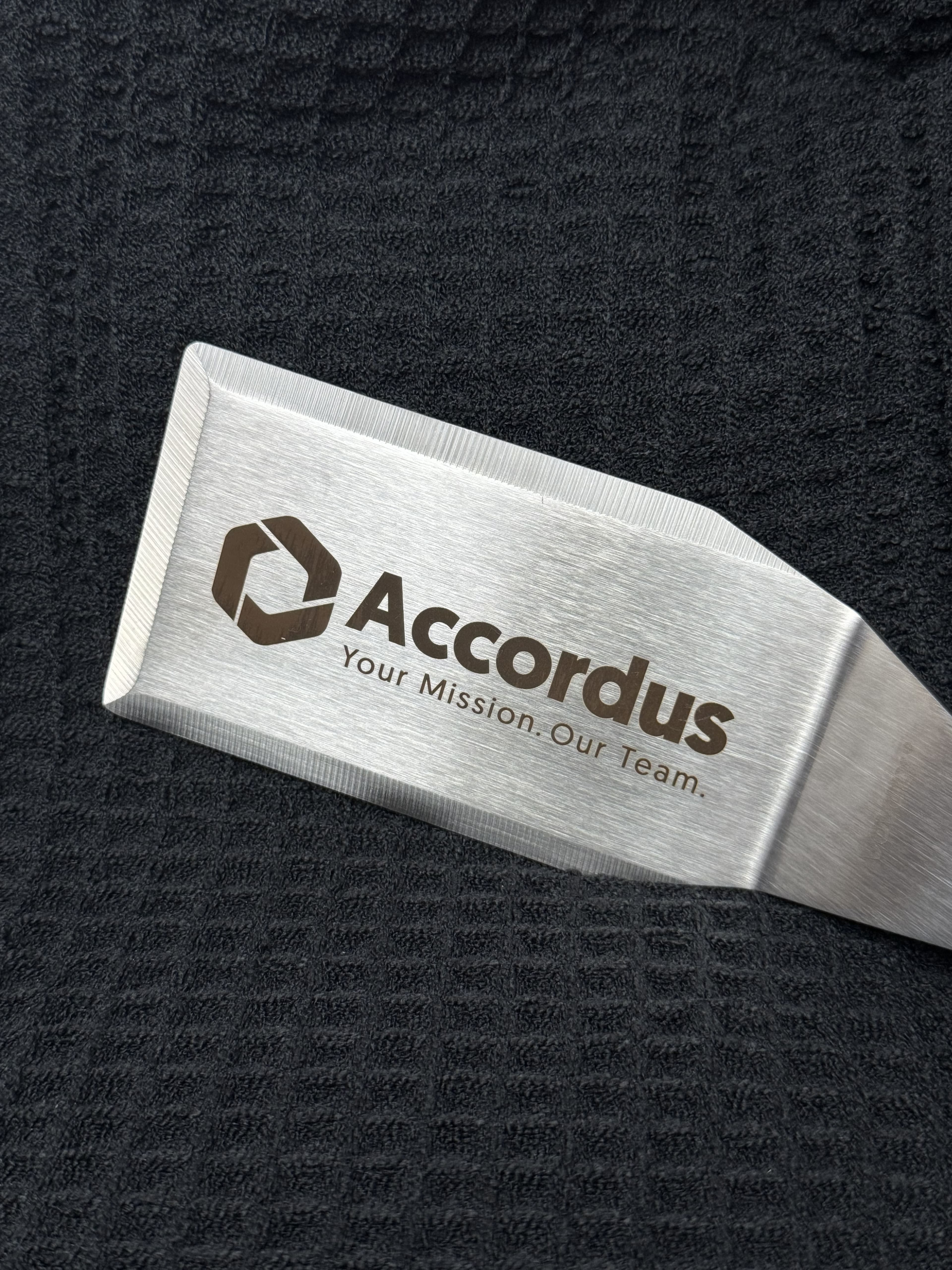 Close-up of Accordus corporate logo engraving on stainless steel